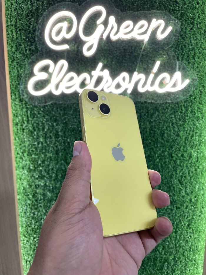 iPhone 14 color Amarillo vibrante, en una mano, destacando su diseño elegante y su sistema de doble cámara, con un fondo brillante y alegre. Disponible en Green Electronics.