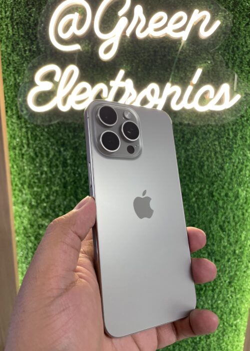 Celular usado en Colombia de alta calidad iPhone 15 Pro Max azul en mano frente a letrero Green Electronics