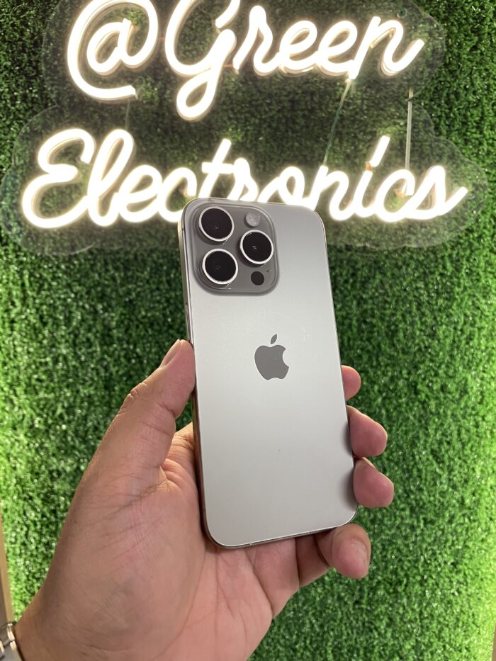 iPhone 15 Pro color titanio natural en mano frente a letrero Green Electronics